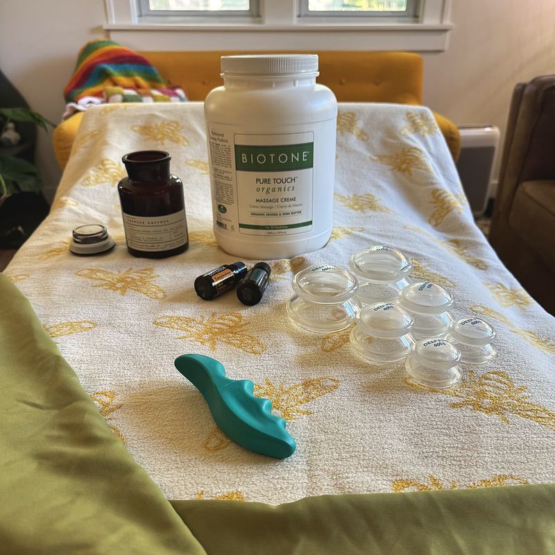 Massage creme, oils, silicone cups and a massage tool laid out on the table